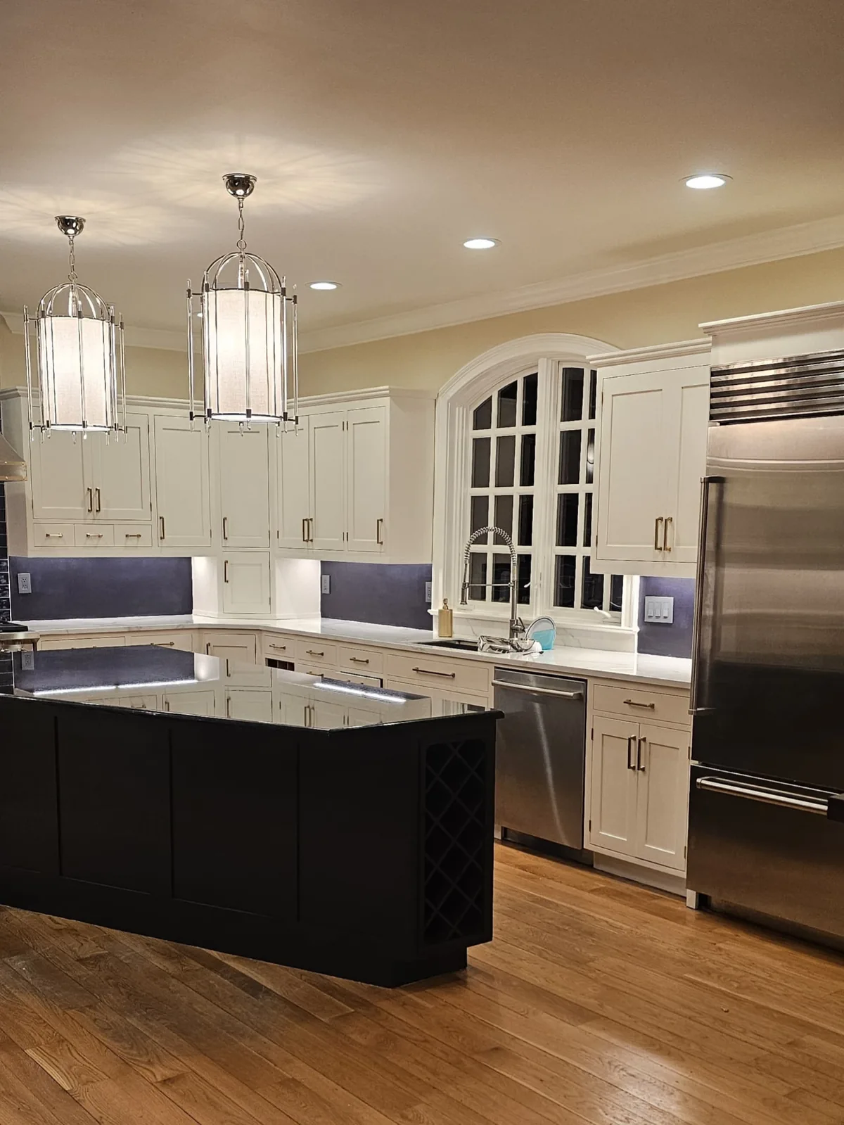 Refinished off-white kitchen cabinets with a black island in a Fairfield County home