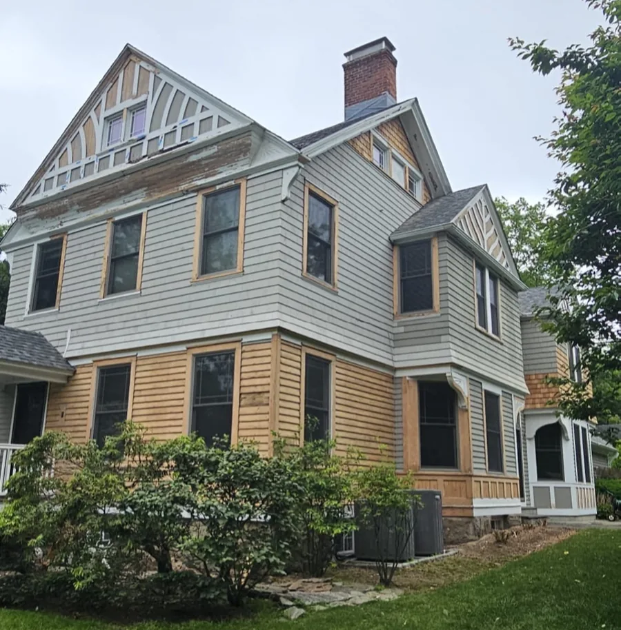 Historic Fairfield County home before painting, with bare wood siding and trim repairs in progress