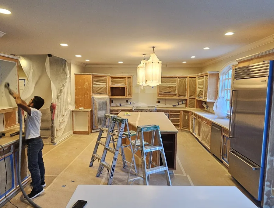 Kitchen fully masked off with cabinets stripped and taped before cabinet refinishing