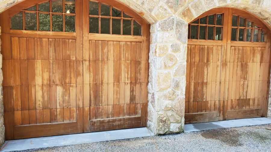 Weathered wood garage doors with faded, peeling stain before refinishing